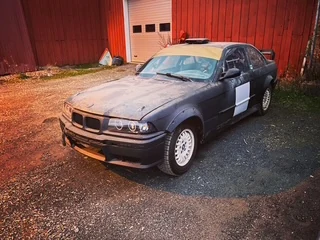 Musta BMW E36 tallin edessä, lokakuu 2022
